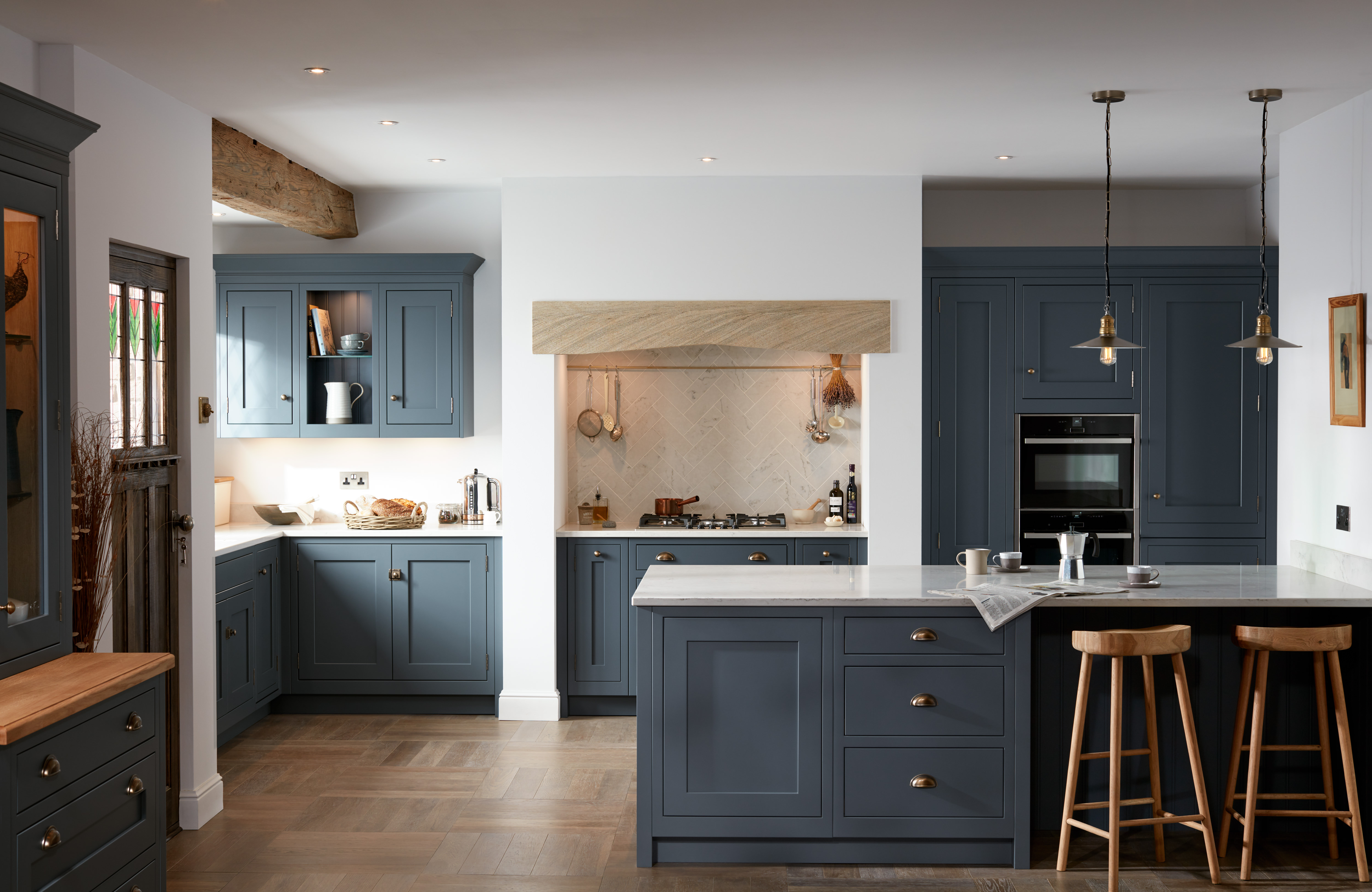 A modern Shaker kitchen in cadet blue, with a kitchen island/breakfast bar and wooden flooring.