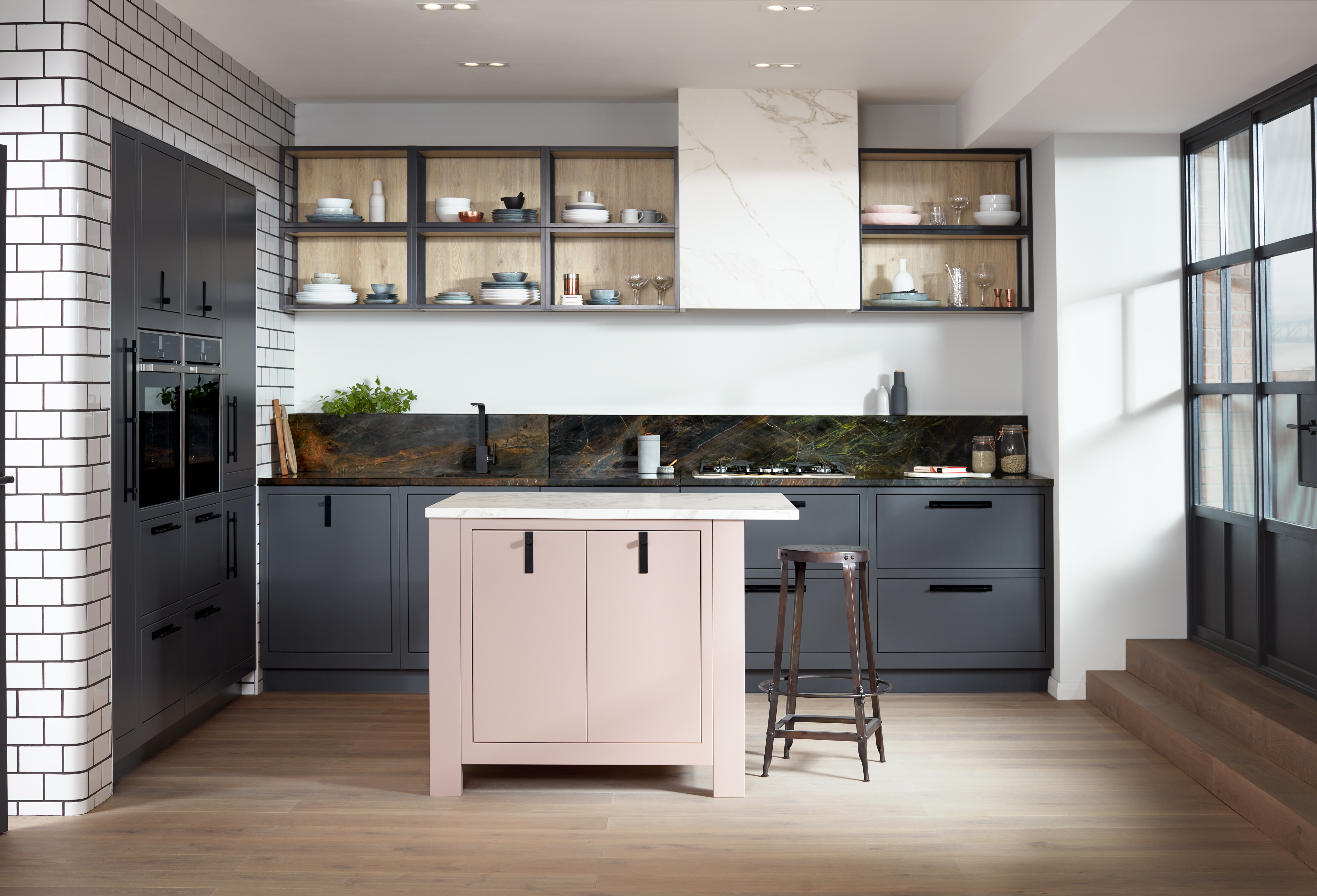 A modern slab kitchen with a small kitchen island, built-in oven and shelf storage.